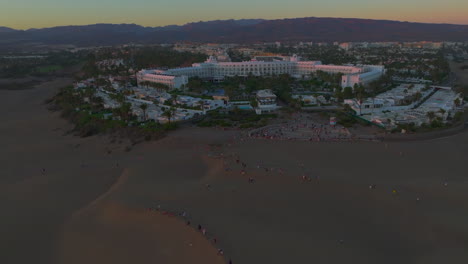 Vista-Aérea-En-órbita-Sobre-Uno-De-Los-Complejos-Turísticos-Ubicados-En-La-Playa-De-Maspalomas-Durante-La-Hora-Dorada.