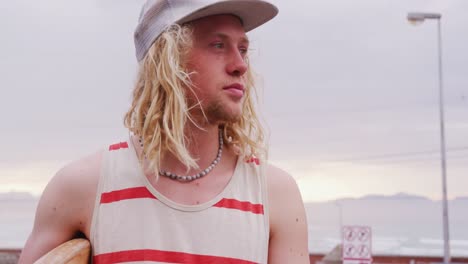 surfista masculino caucásico con una tabla de surf de madera