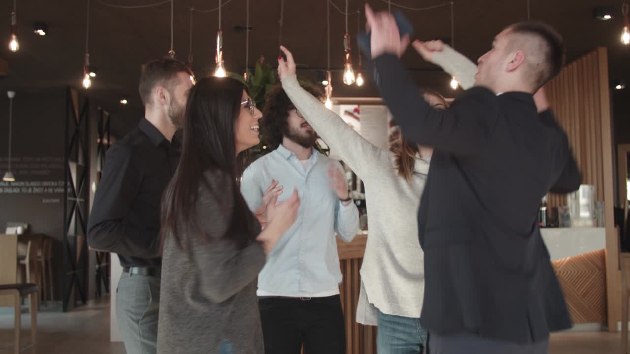 5명의 친구들이 커피하우스에서 축하하고 있다.