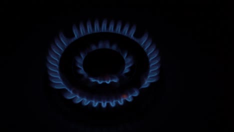 close-up, the gas burner burns and slowly goes out on the kitchen home gas stove on a black background. the concept of the energy crisis. termination of gas supplies. without people. top view. 4k.