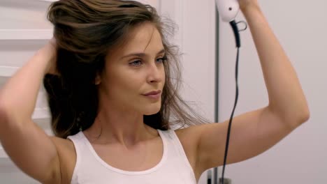 Close-up-of-woman-drying-her-hair-in-bathroom