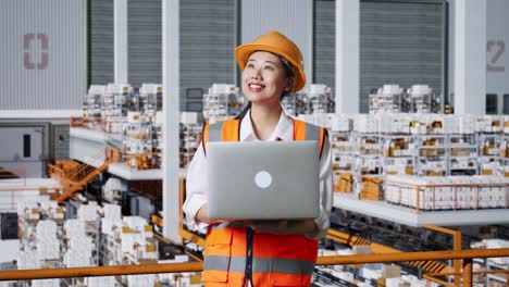 female engineer in warehouse with laptop