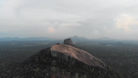 aerial cinematográfico tilt up vuelo de pidurangala y sigiriya roca al atardecer. uno de los lugares más turísticos de sri lanka. rodado en 4k