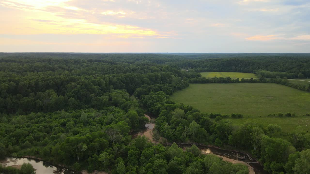 Flying over a creek in the Tennessee countryside during sunset