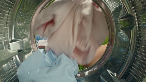 loading laundry in a washing machine in a garden