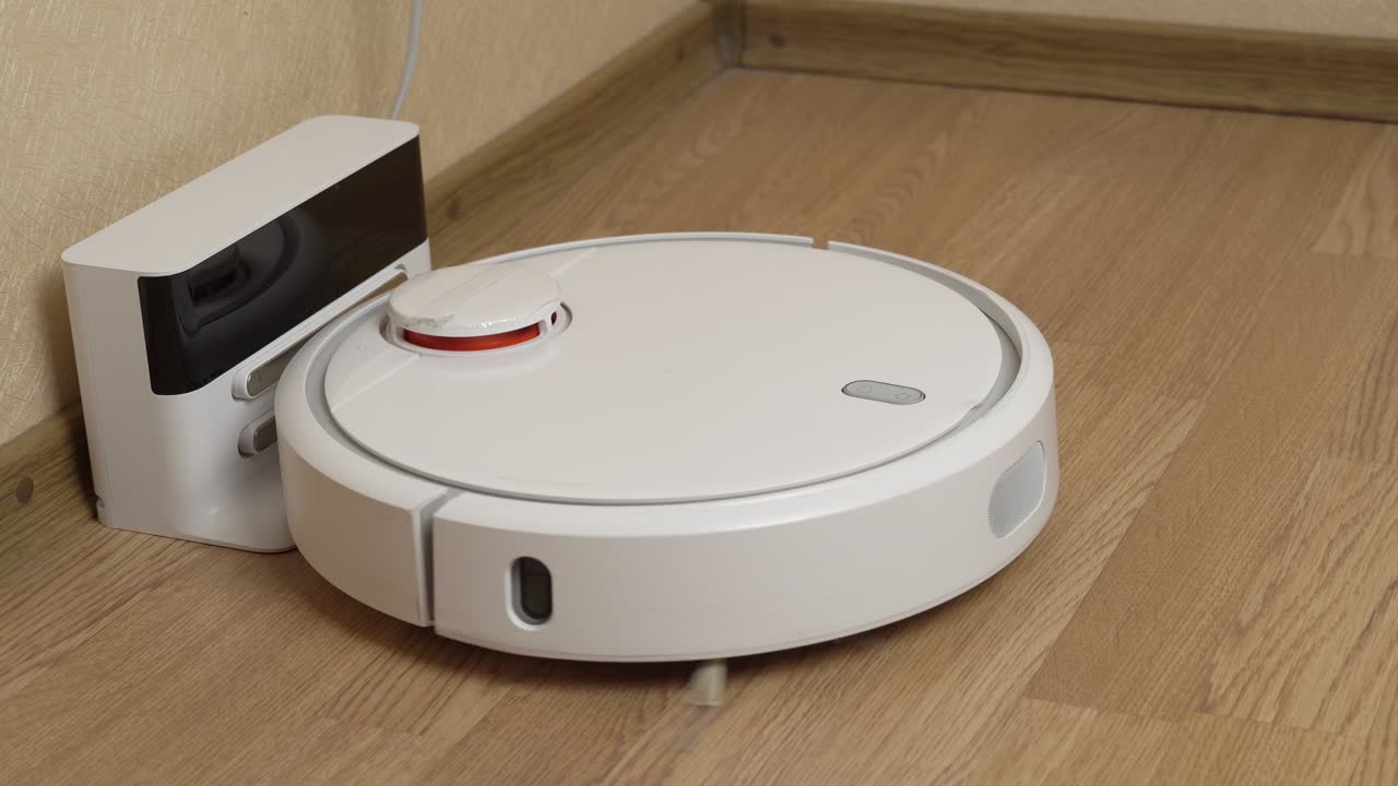 la aspiradora robótica blanca termina de limpiar y se dirige a su estación de carga