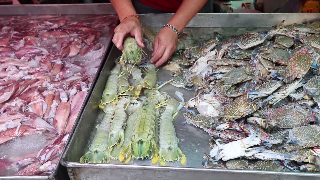 manos clasificando peces y crustáceos en el mercado