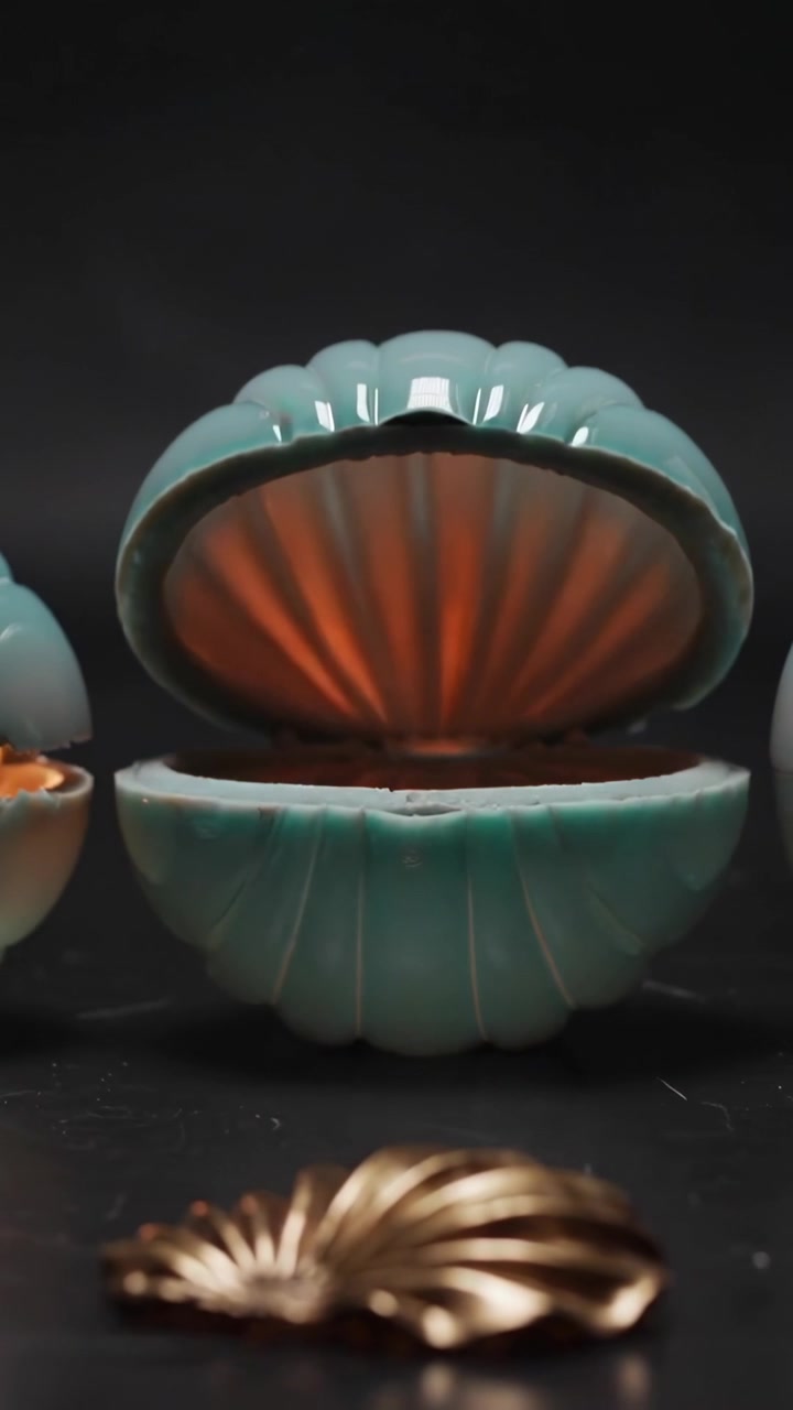 Vertical video: Opening teal shell box hinge moving, revealing copper liner, gold leaf on black top