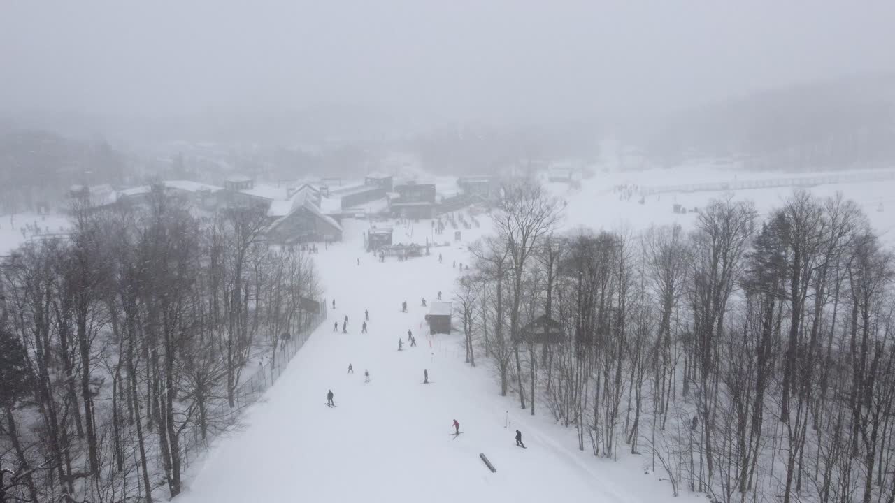 View of people skiing down a slope on a cloudy winter day in Quebec, Canada