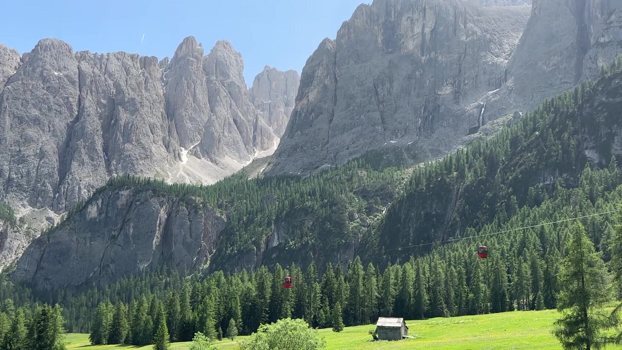 Fængslende optagelser af Dolomitternes dramatiske bjerg- og skovlandskab med svævebaner, der glider gennem baggrunden, fanger den perfekte blanding af natur og alpin infrastruktur, Syd.