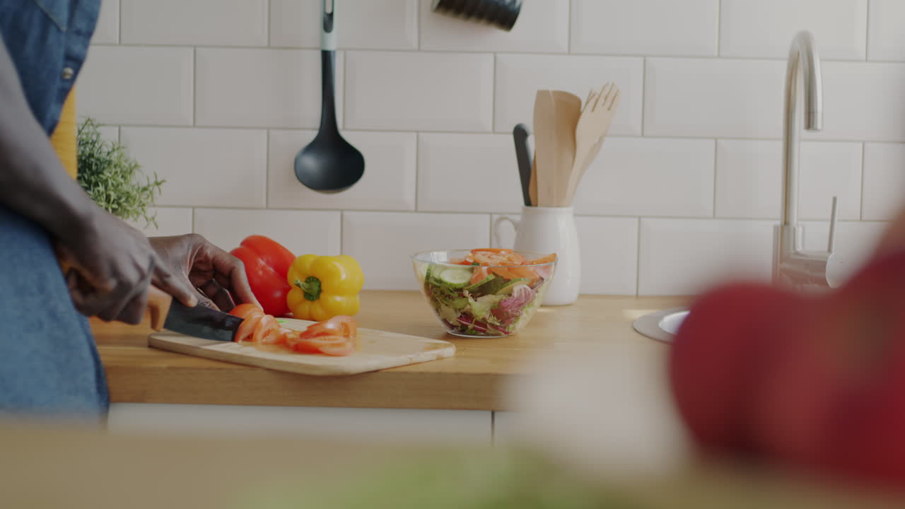 Person chopping vegetables for salad in a kitchen