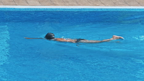 una joven sensual relajándose en la piscina.