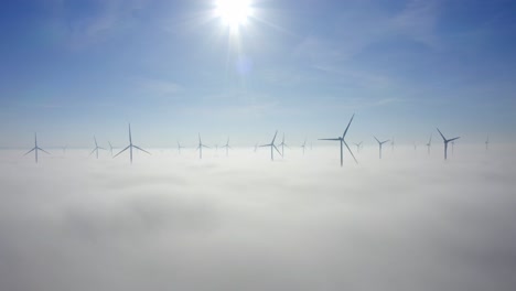 turbinas de viento sobre densas nubes de niebla durante la mañana soleada