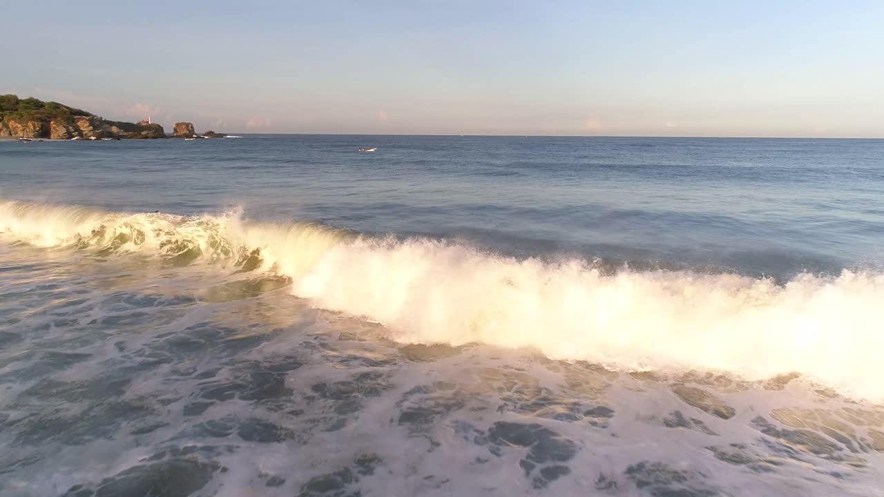 toma aérea de una ola rompiendo y salpicando en la mañana, playa zicatela, puerto escondido, oaxaca