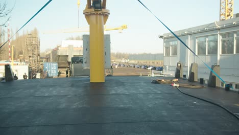 huge truck with flat bed trailer transporting huge boat into shipyard