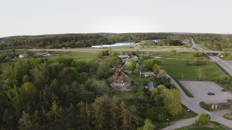 wide aerial drone shot flying in towards sunvära kvarn museum and windmill in sweden.