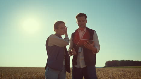 agronomists team holding tablet computer in sunlight. agritech industry workers