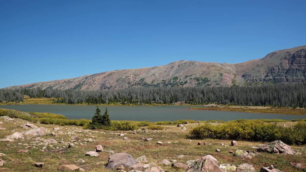 impresionante lago del castillo rojo inferior en el bosque nacional de uinta alto con montañas áridas, pinos y pequeño follaje en un sendero de diez millas para mochileros entre utah y wyoming