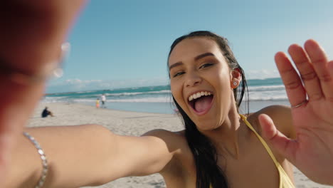 Joven-Mujer-De-Raza-Mixta-Teniendo-Video-Chat-En-La-Playa-Chica-Lanzando-Un-Beso-A-La-Cámara-Compartiendo-Vacaciones-De-Verano-Usando-Un-Teléfono-Inteligente-Mostrando-Aventuras-De-Viaje-Divirtiéndose-En-Vacaciones