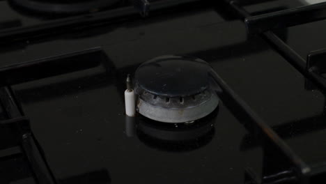 close-up view of a small kitchen gas stove burner with a blue flame, representing cooking, heating, and meal preparation at home