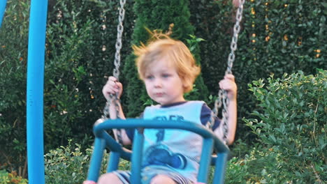 niño gracioso divirtiéndose con el columpio de cadena