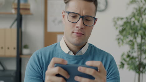 man playing a game on his phone in an office