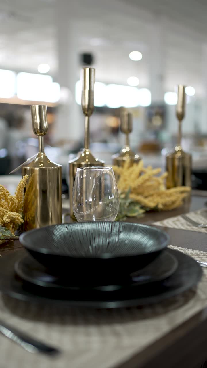 This elegant dining arrangement features stylish black plates, glassware, and gold accents. The setting creates a warm atmosphere for guests at a modern restaurant