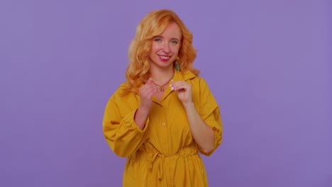 Smiling-redhead-girl-makes-heart-gesture-demonstrates-love-sign-expresses-good-feelings-and-sympathy