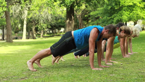 grupo de fitness haciendo yoga en el parque
