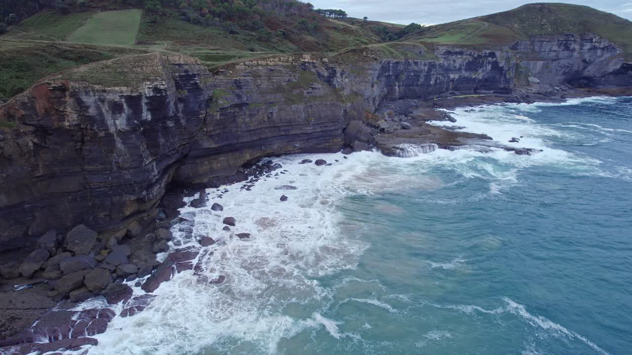 drone captura la isla de isla, cantabria y el mar cantábrico de color azul y esmeralda desde una gran altura