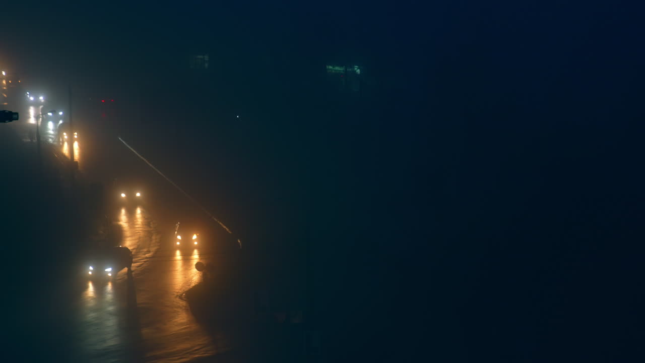 Traffico cittadino notturno nella nebbia