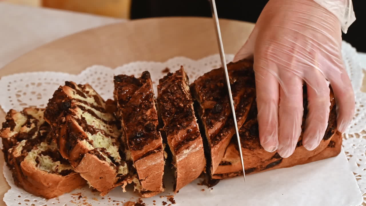 A woman cutting a baked roll with stuffing on a plate