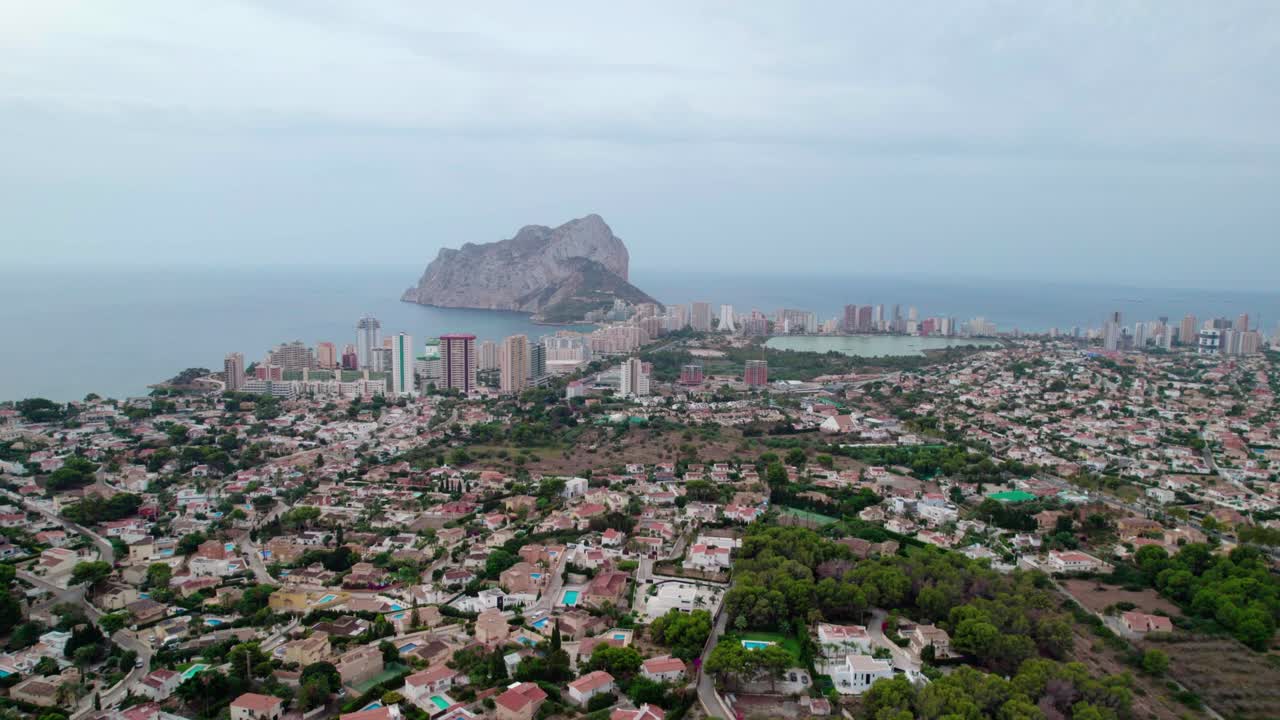 Calpe Coastal Town With Peñón de Ifach Rock In The Background On The Costa Blanca In The Marina Alta Region, Spain. Aerial Wide Shot