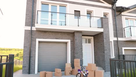 rear view on african american young family with small kids standing at yard of house and father pointing with finger to the second floor