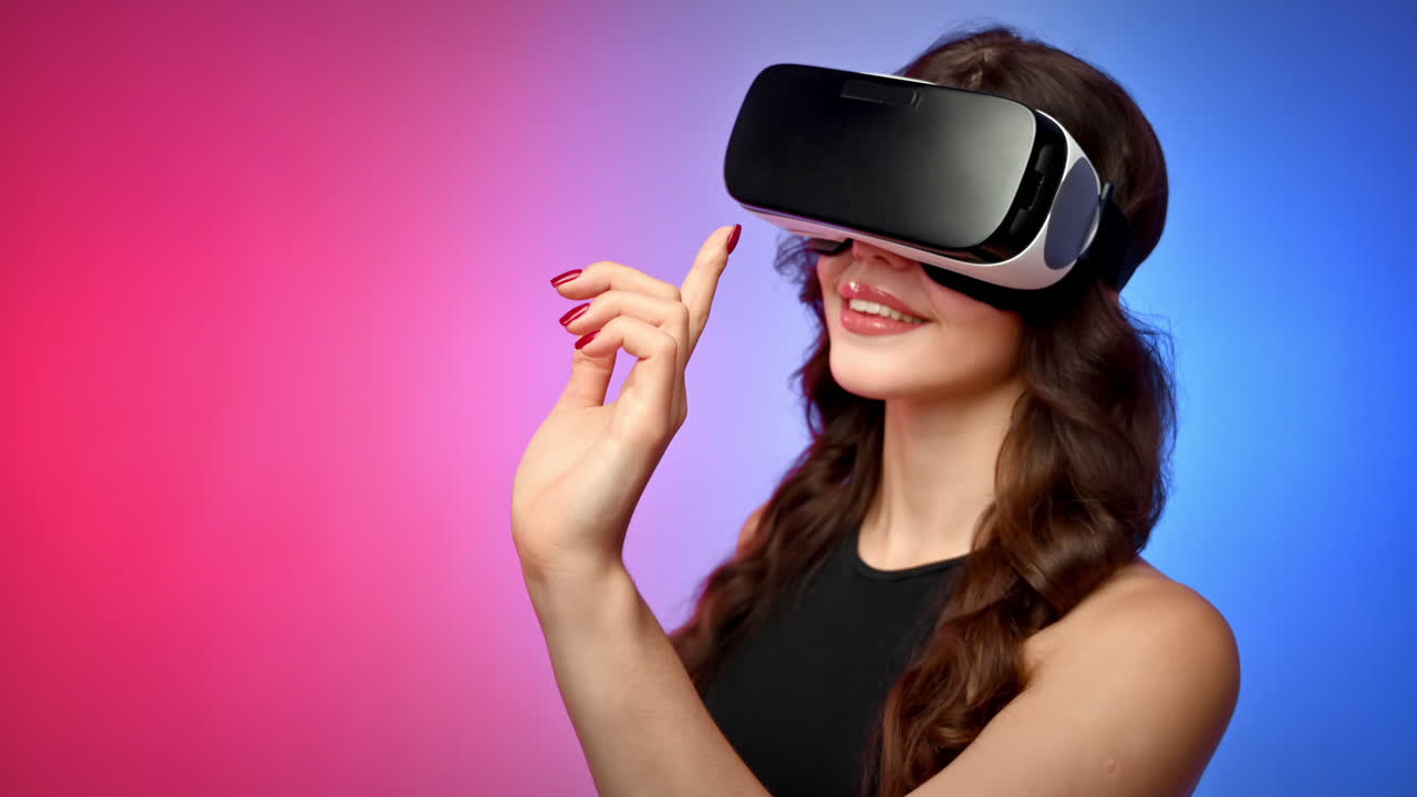 Young smiling woman in a tracksuit using virtual reality VR headset in a studio with blue and red background