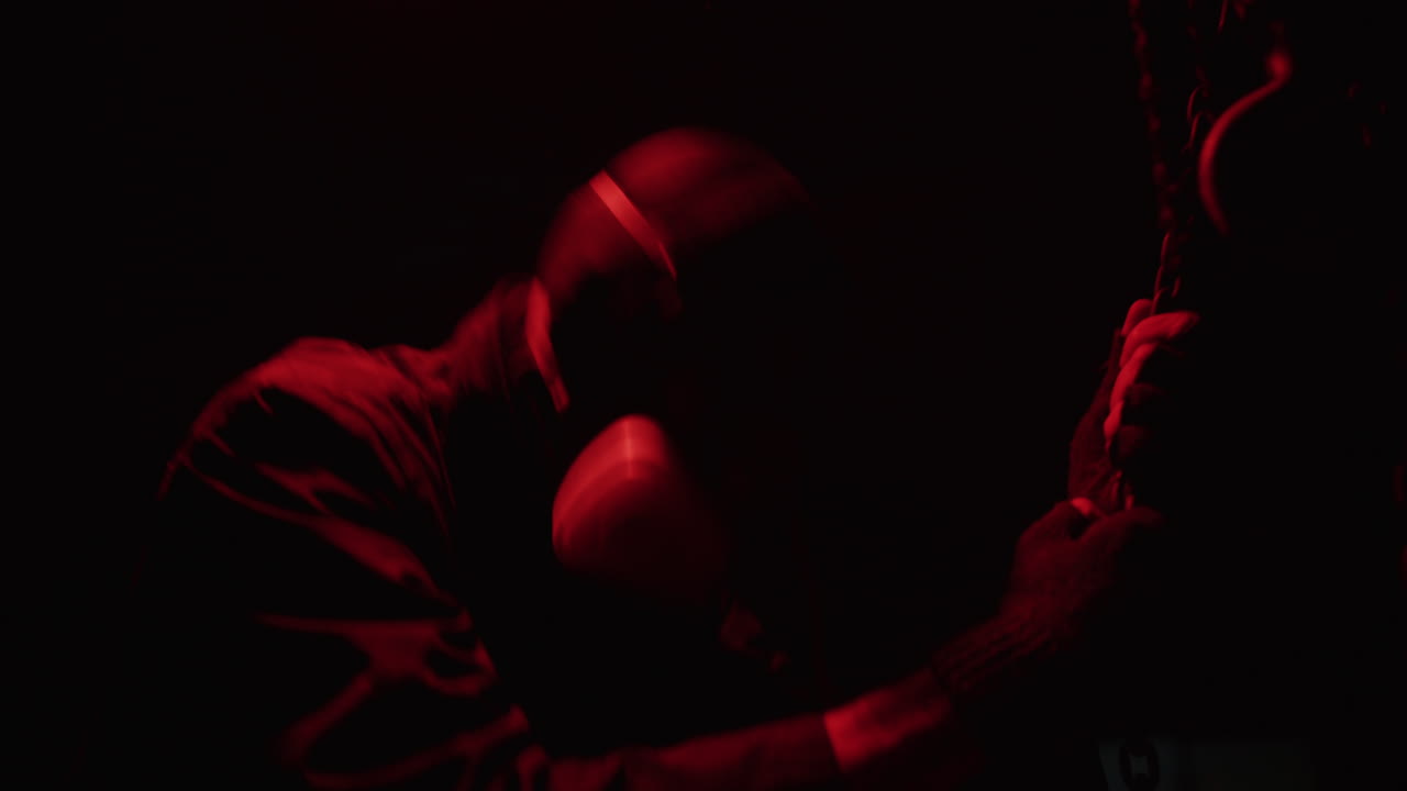 Person in Protective Gear with Chain in Red Light