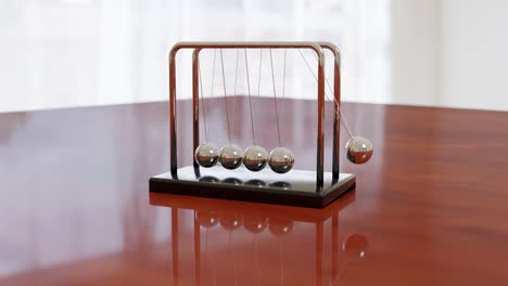 la cuna de newton balanceándose en una mesa de madera con un fondo claro. bucle. concepto de equilibrio.