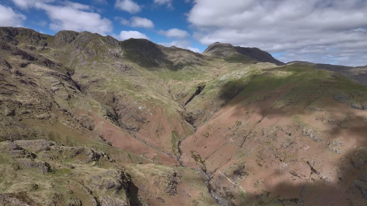 las escarpadas montañas de los lagos se arrugan los acantilados y el arco cae con las sombras de las nubes en movimiento
