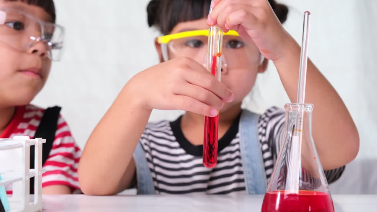 los niños están aprendiendo y haciendo experimentos científicos en el aula. dos hermanas pequeñas jugando a experimentos científicos para la escuela en casa. experimentos científicos fáciles y divertidos para los niños en casa.