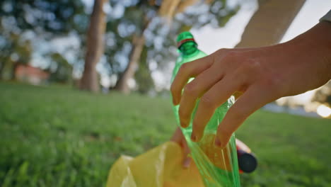 activist hand holding plastic bottle at cleanup park closeup. eco volunteer