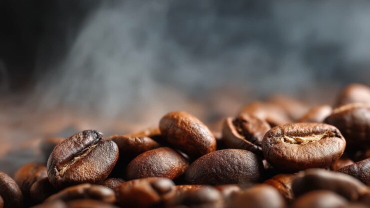 Aromatic Coffee Beans Piled Together, Emitting Wisps of Steam in a Rich, Dark Setting, Capturing the Essence of Freshly Roasted Coffee for Enthusiasts and Connoisseurs