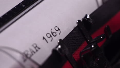 year 1969, typing in vintage typewriter on blank white paper, close up