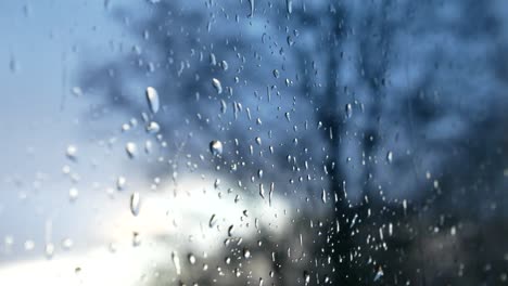 Gotas-De-Tormenta-Lluviosa,-Mal-Humor-Caen-Por-El-Cristal-De-La-Ventana-Closeup-Bokeh