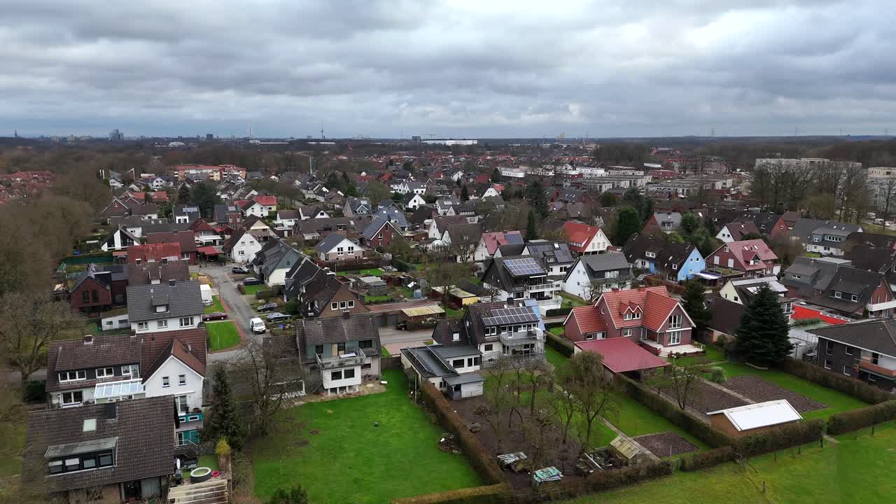 Aerial flyover german neighborhood with single Family homes on cloudy day. Solar panels installed on roof of houses. Cloudy day in German Town. Drone forward wide shot.