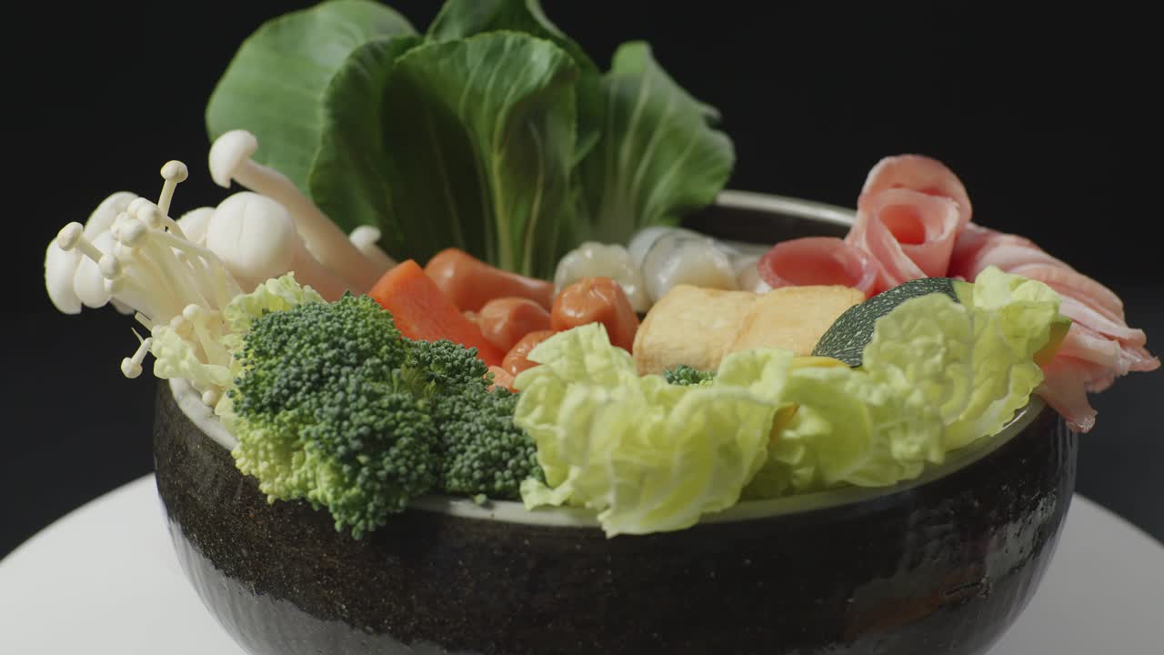 검은색 배경의 부에서  테이블 위에 회전하는 샤부 재료의 비의 근접