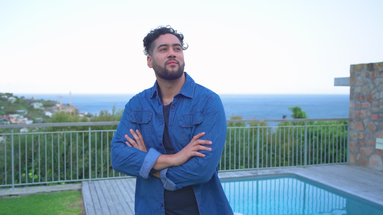 Zoom della telecamera, uomo di mezza età che incrocia le braccia, spostando lo sguardo per ammirare l'acqua della piscina sulla terrazza a bordo piscina