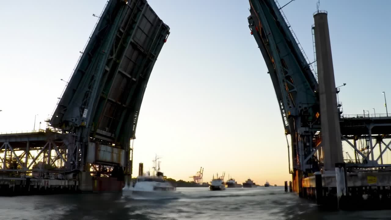 A Majestic Bridge Opening Over Tranquil Waters at Sunset, Showcasing Engineering Marvel and Scenic Harbor with Ships in the Distance