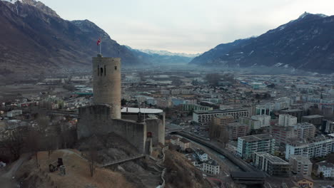 drone flying past old castle and revealing a busy modern city