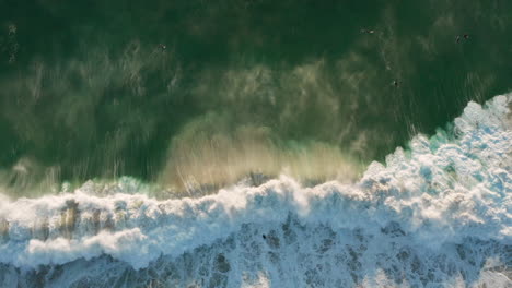 Hermosa-Toma-De-Drones-Que-Muestra-Una-Gran-Ola-Rompiendo-Con-La-Puesta-De-Sol-En-Llandudno,-Ciudad-Del-Cabo