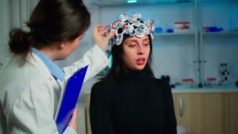 paciente con auriculares eeg discutiendo con el investigador médico durante el examen